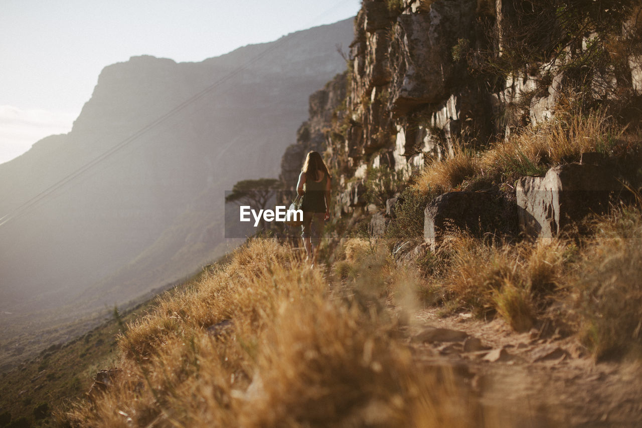 Rear view of woman walking on mountain