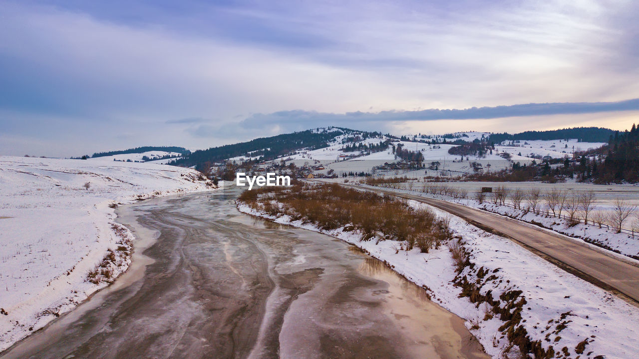 Snow covered land against sky