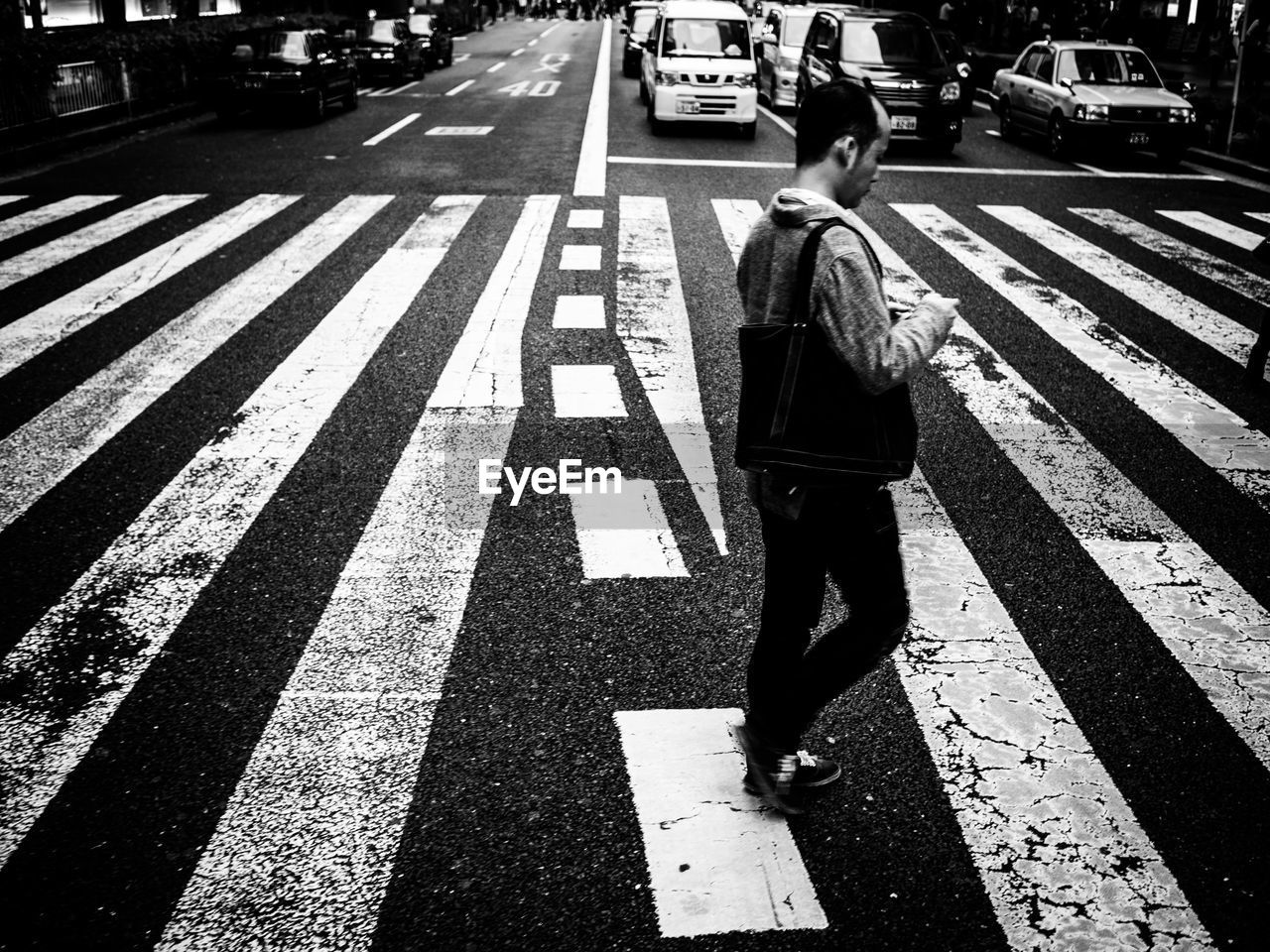 FULL LENGTH REAR VIEW OF MAN WALKING ON ROAD