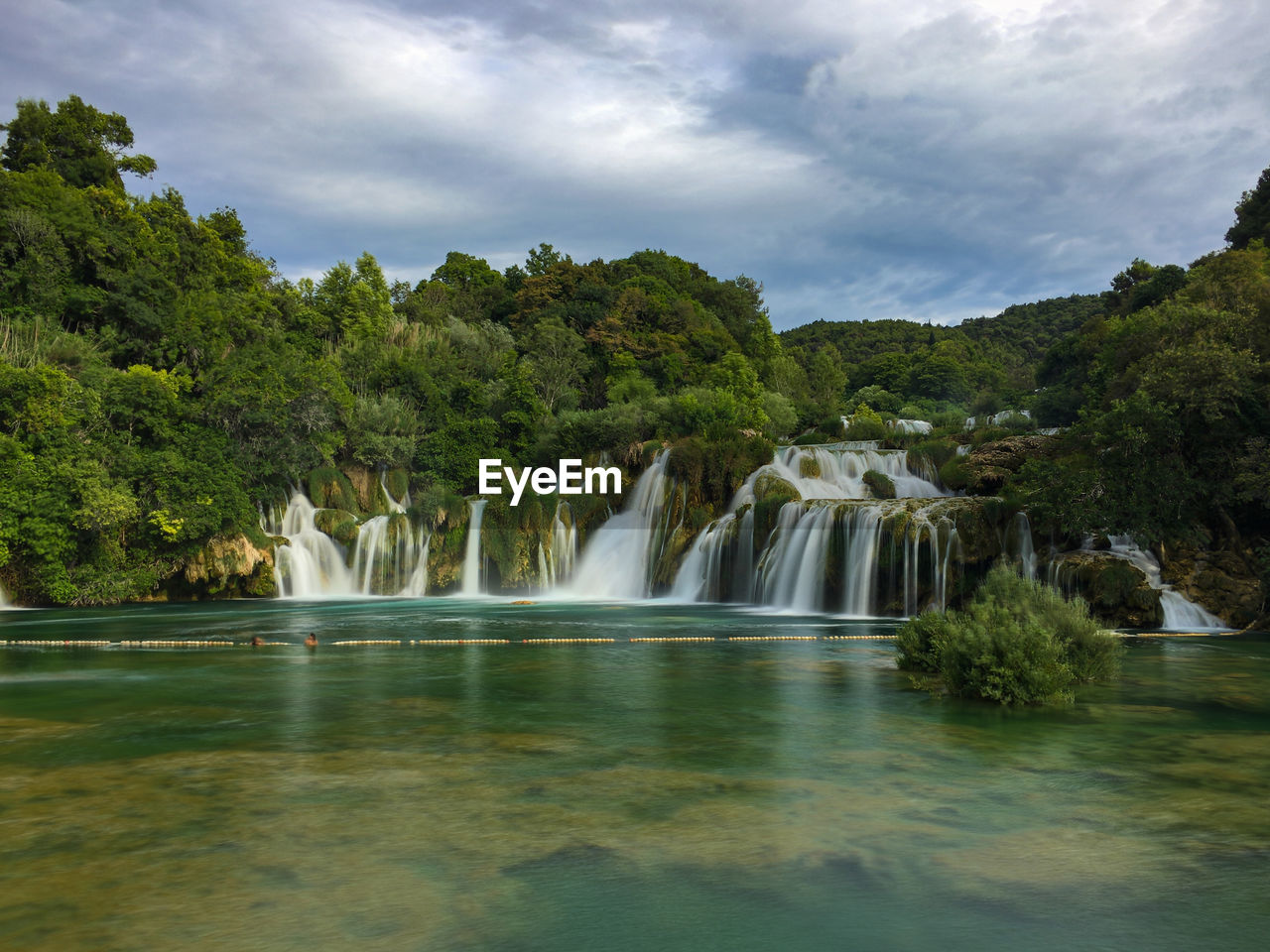 Scenic view of waterfall against sky