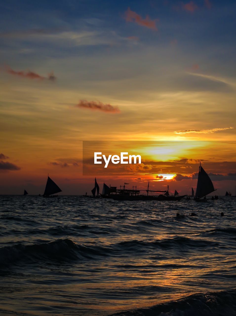 SILHOUETTE BOAT SAILING IN SEA AGAINST ORANGE SKY