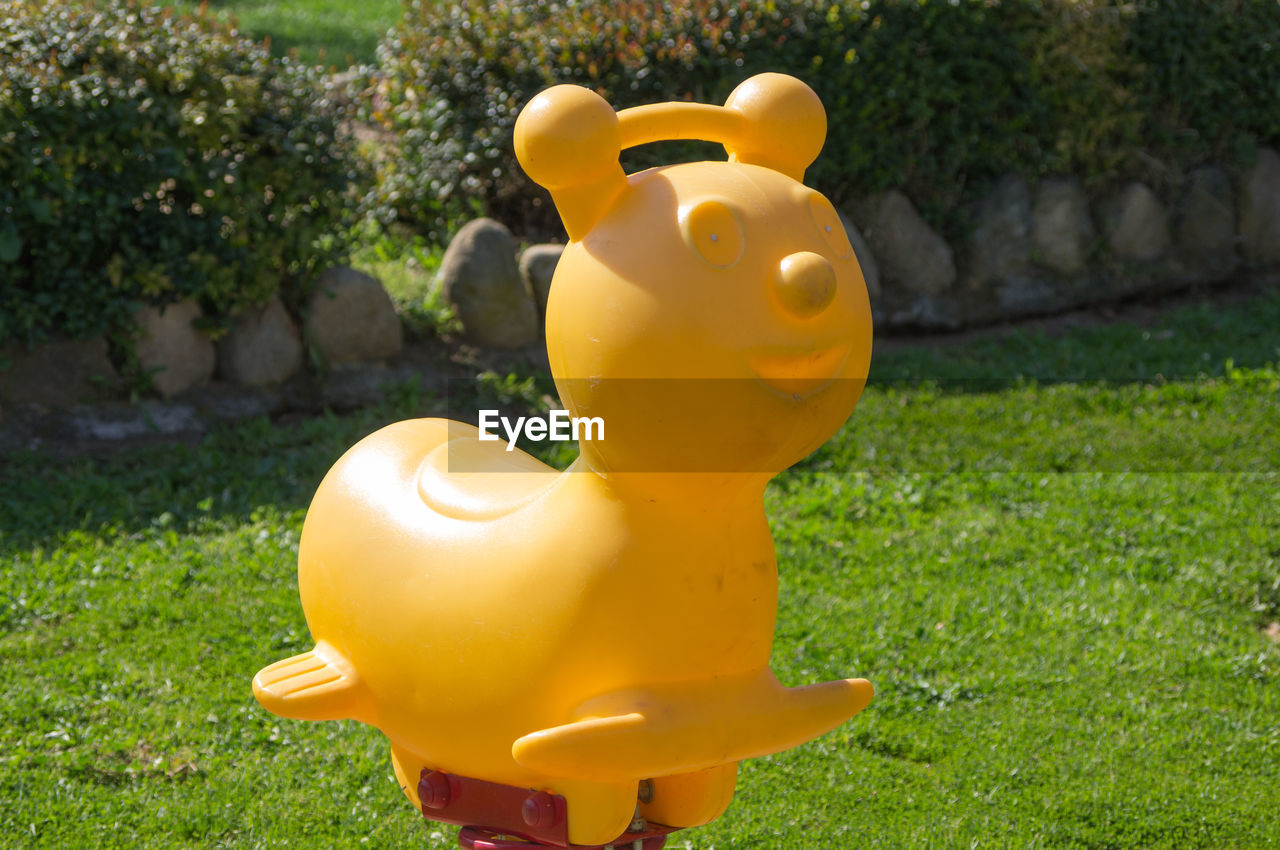 Empty yellow play equipment at park on sunny day