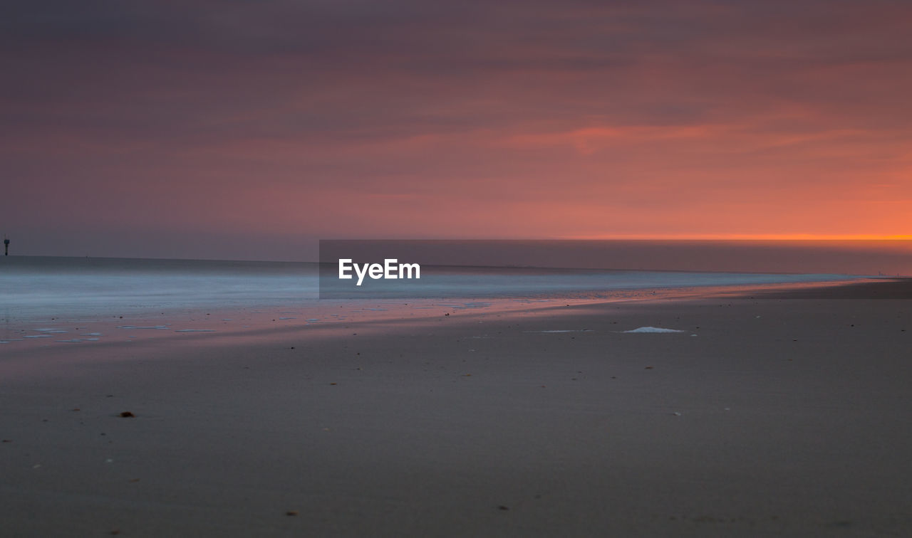 Scenic view of beach against sky during sunset