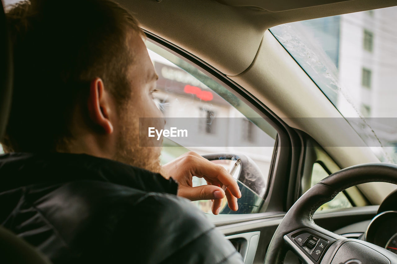 Close-up of man smoking in car