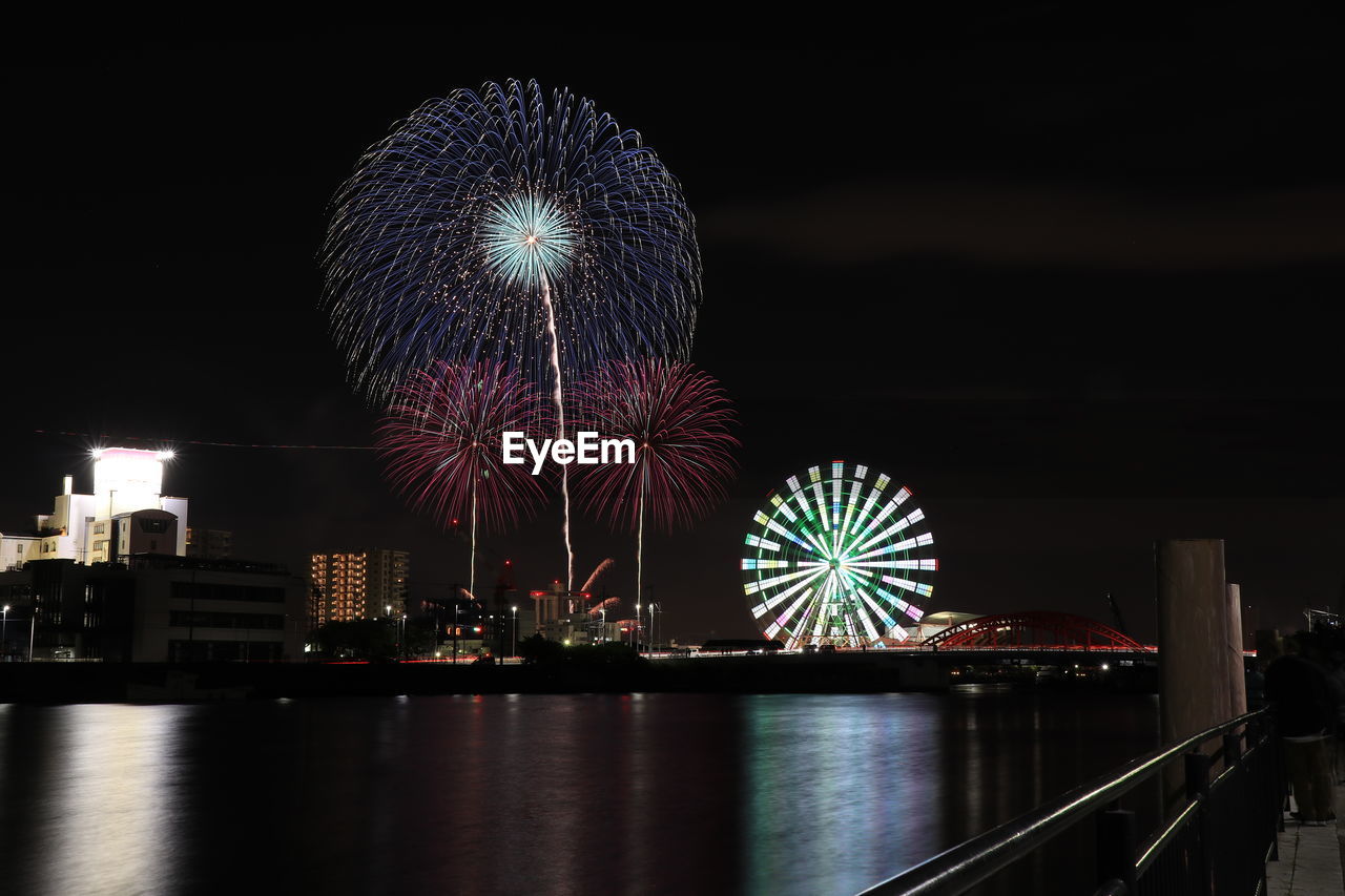 FIREWORK DISPLAY OVER RIVER AGAINST SKY
