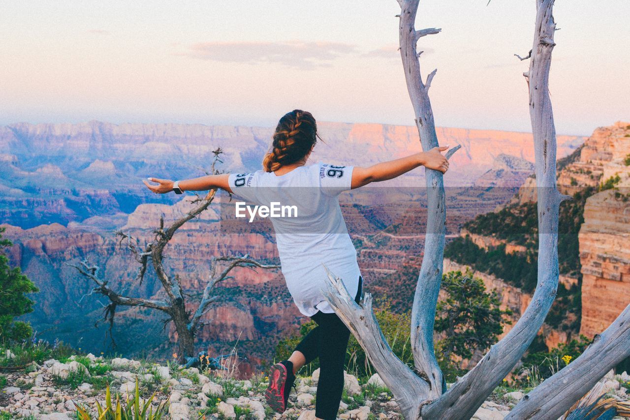 Rear view of woman with arms outstretched while standing at grand canyon national park