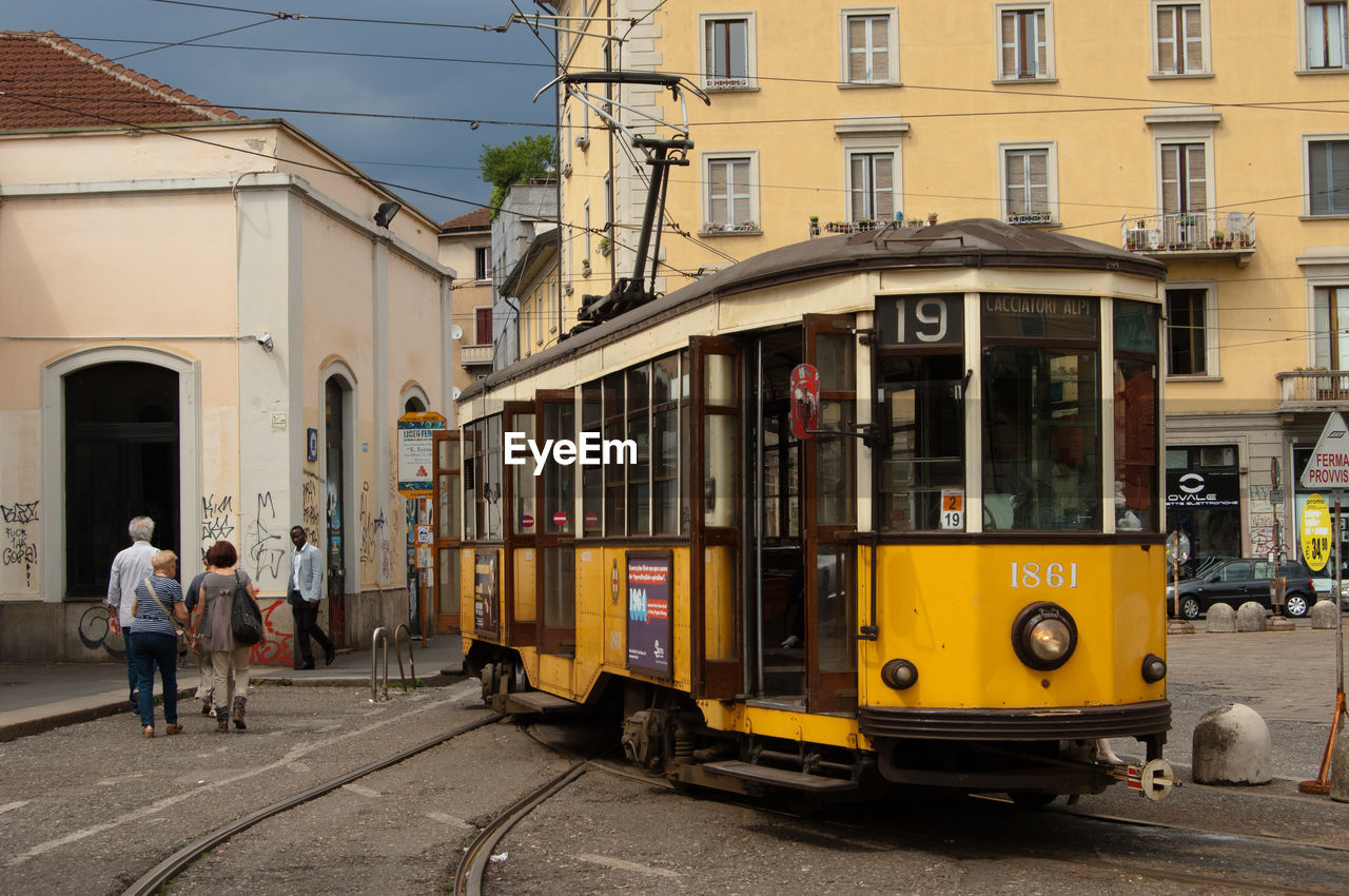 Tram on street against buildings