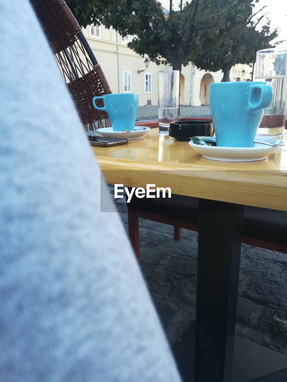 CLOSE-UP OF COFFEE CUP AND TABLE IN CAFE