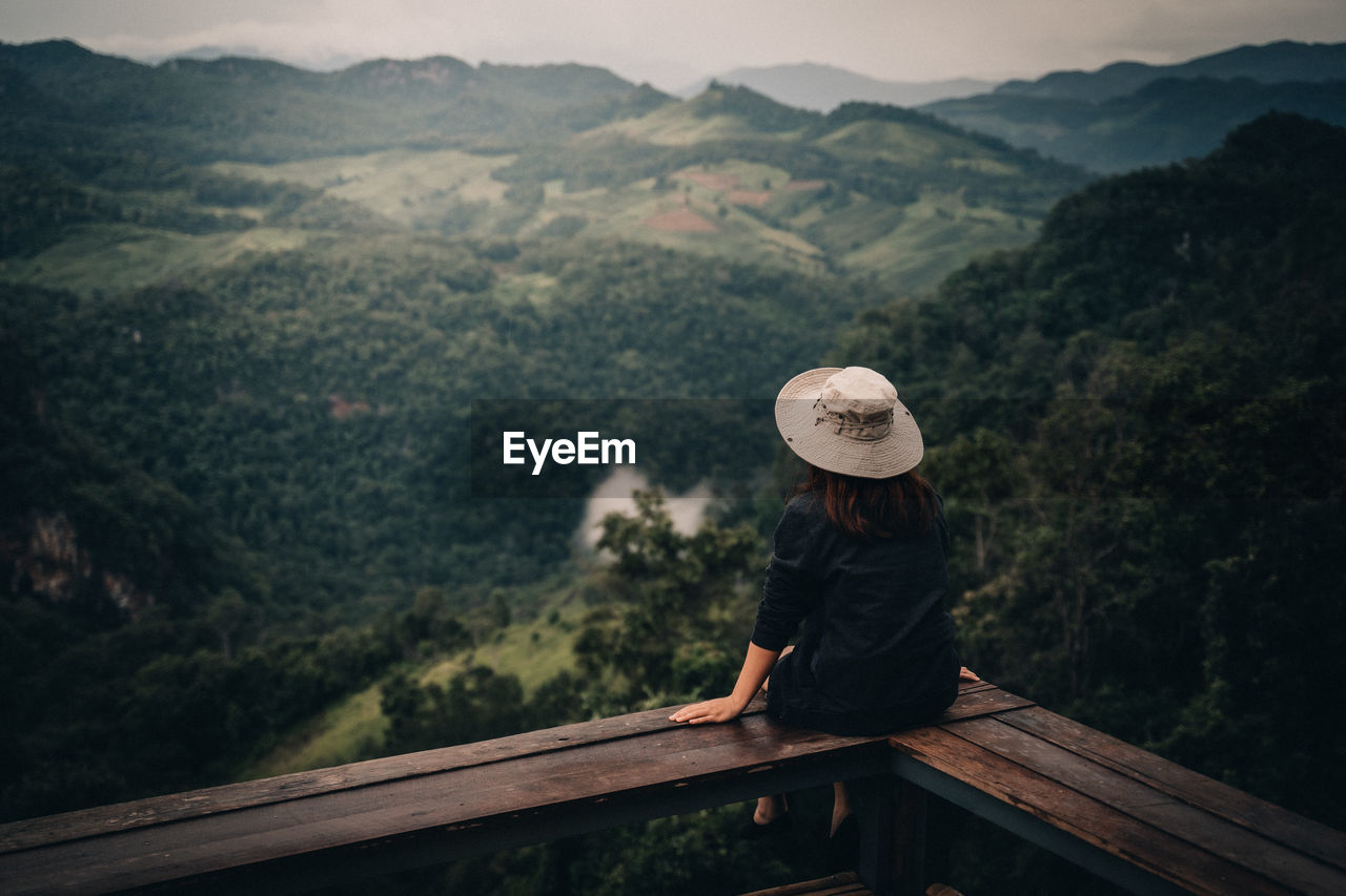 REAR VIEW OF WOMAN LOOKING AT MOUNTAIN