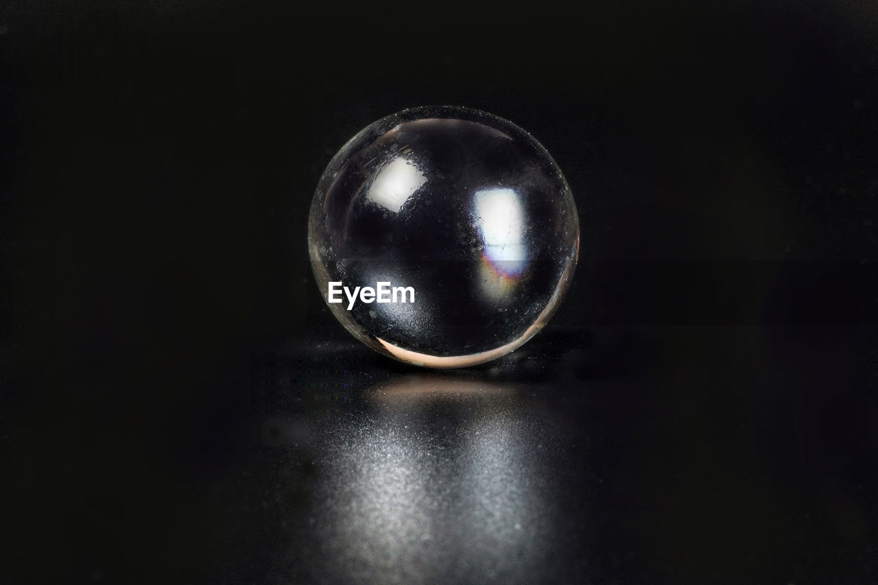 CLOSE-UP OF CRYSTAL BALL ON METAL