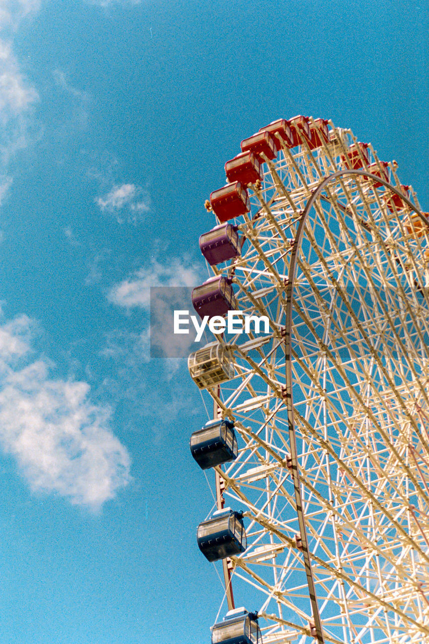 Low angle view of ferris wheel against blue sky