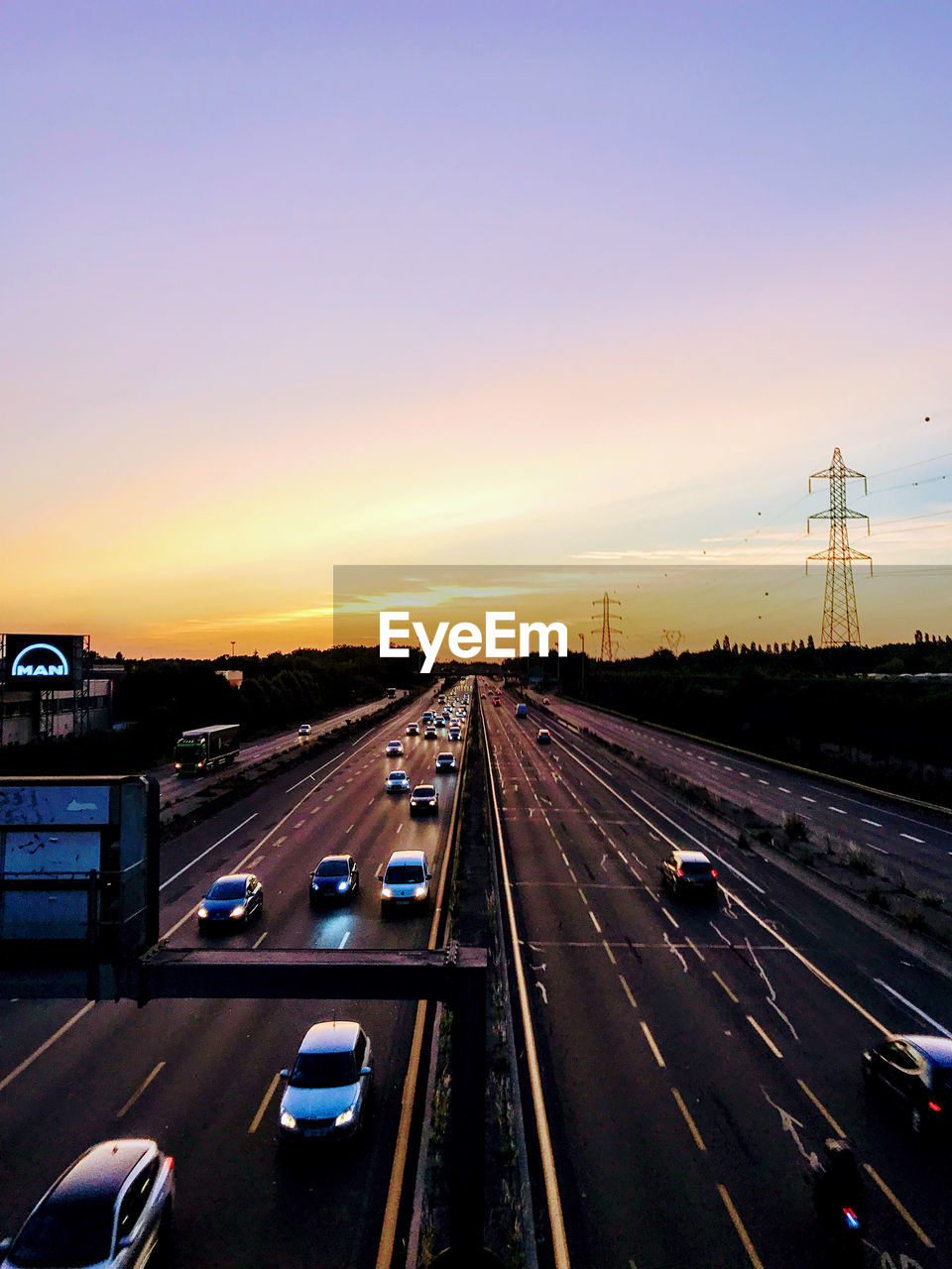 VEHICLES ON HIGHWAY AT SUNSET