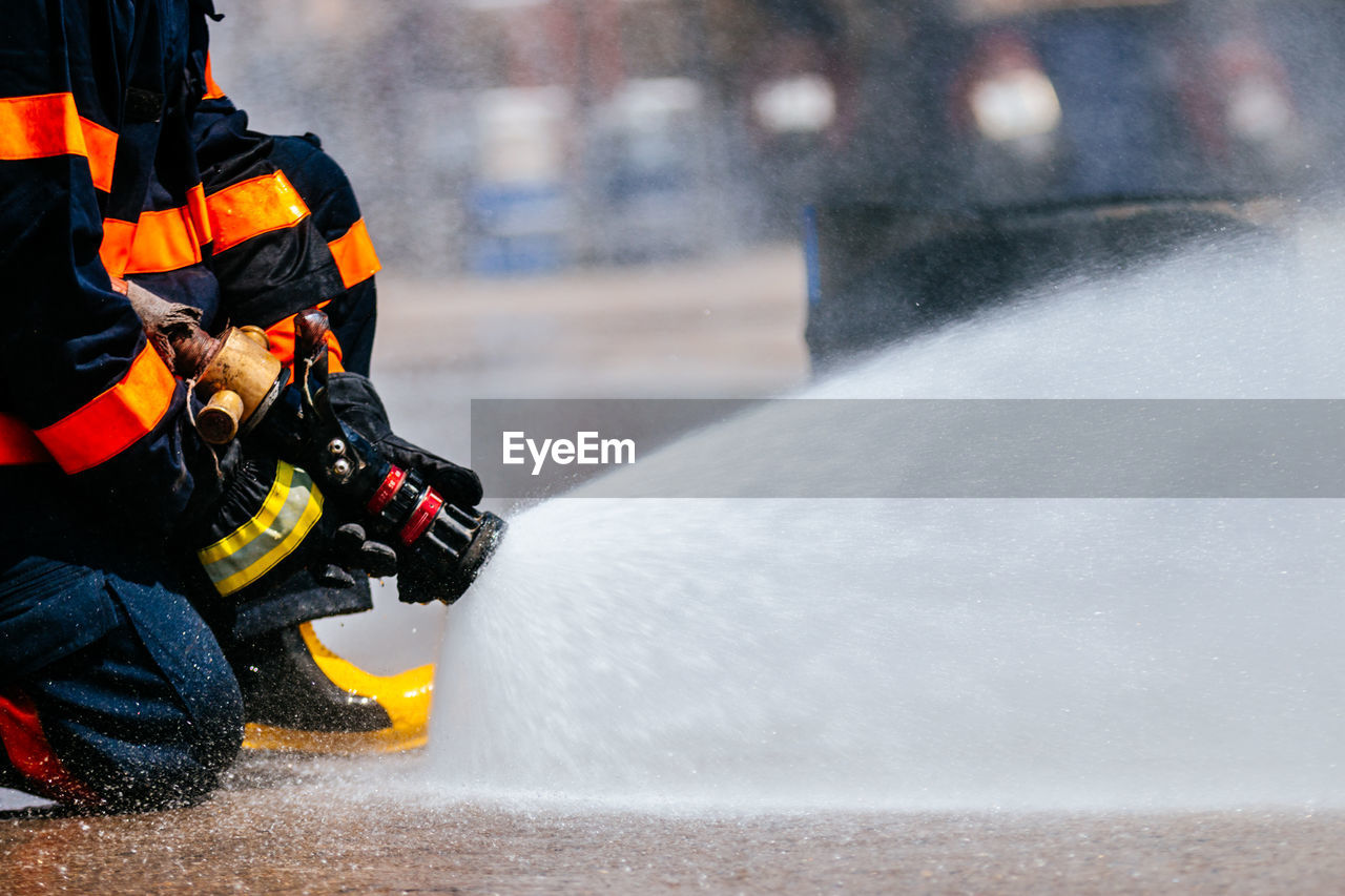 Low section of firefighter spraying water