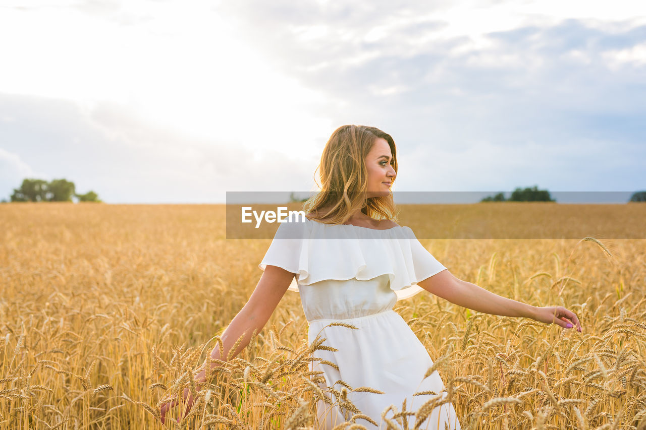 WOMAN STANDING IN FIELD