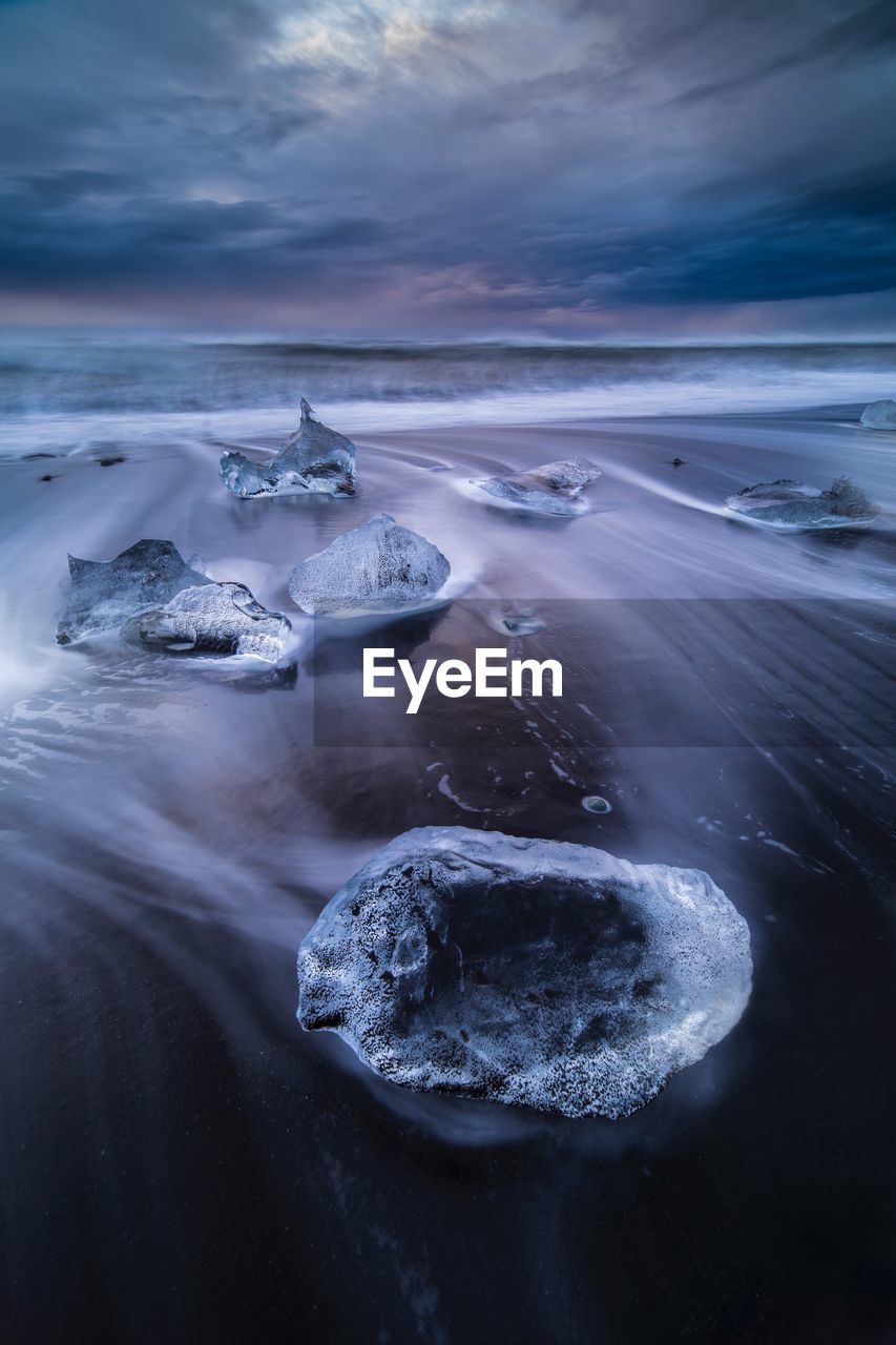 High angle view of ice in sea against sky during sunset