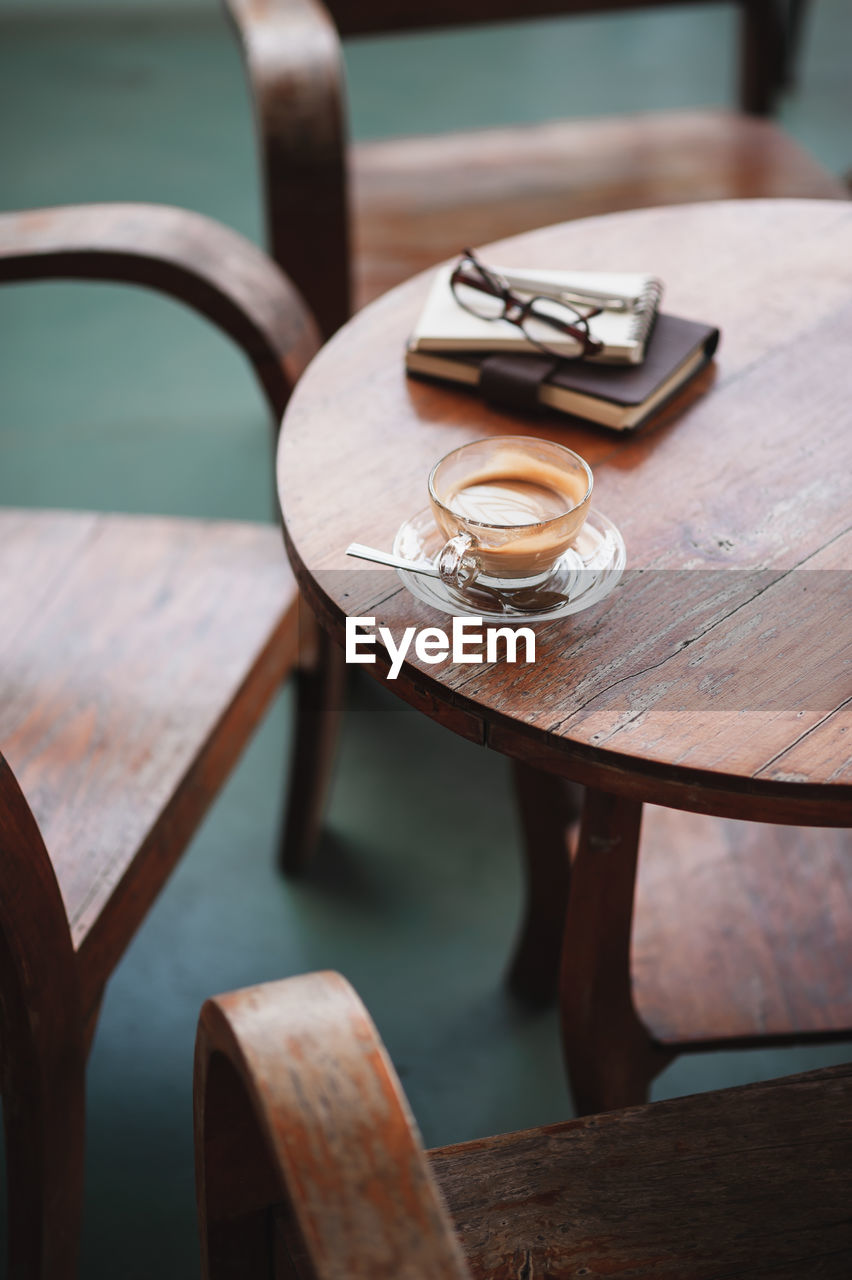 High angle view of coffee cup by books on table