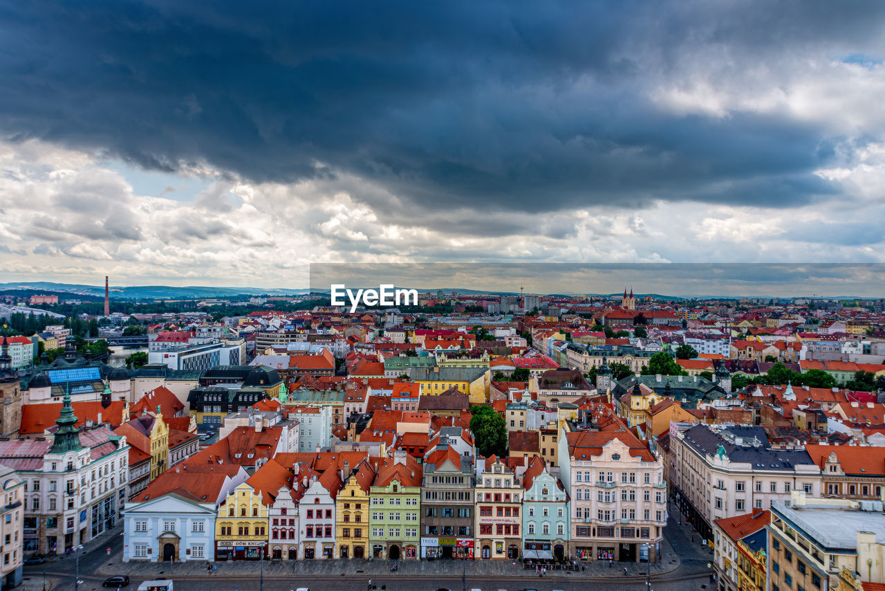 HIGH ANGLE VIEW OF HOUSES IN TOWN AGAINST SKY