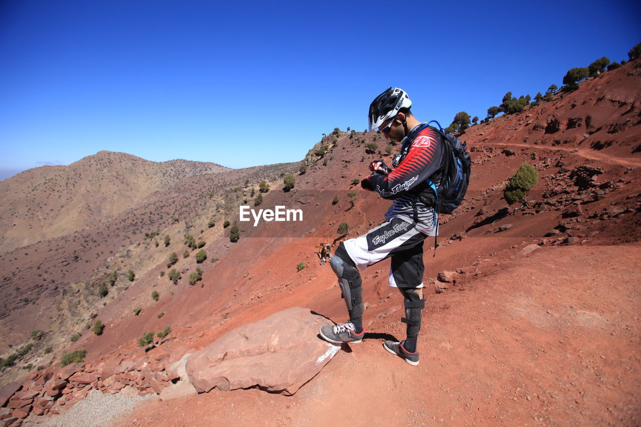 FULL LENGTH OF WOMAN ON MOUNTAIN LANDSCAPE