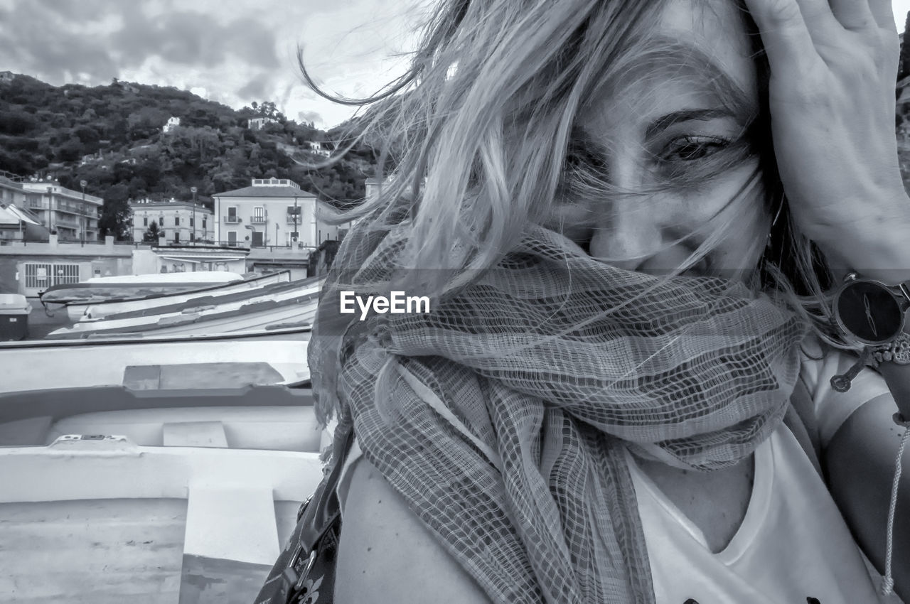 Portrait of woman wearing scarf in city