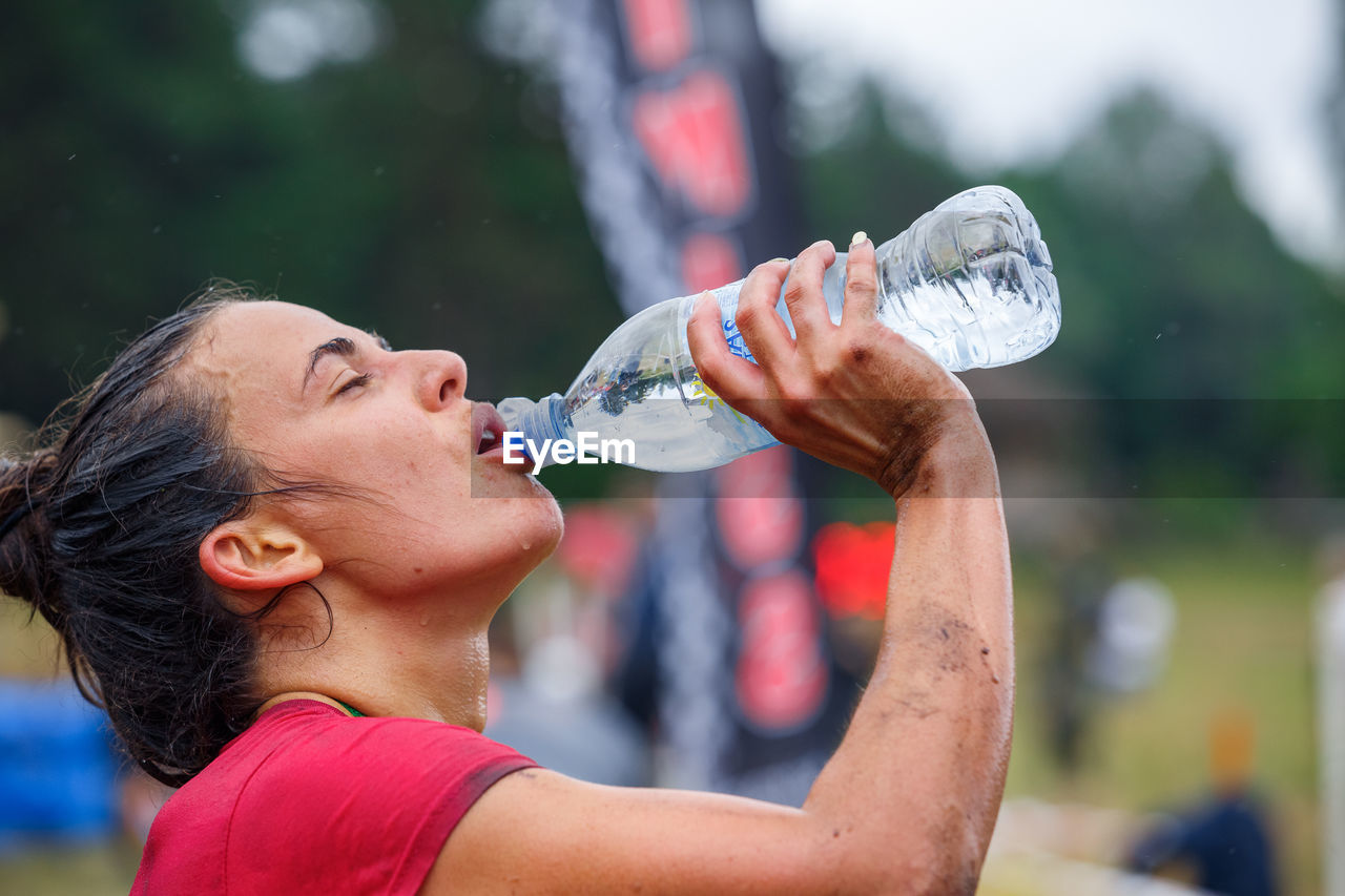 MIDSECTION OF WOMAN DRINKING WATER