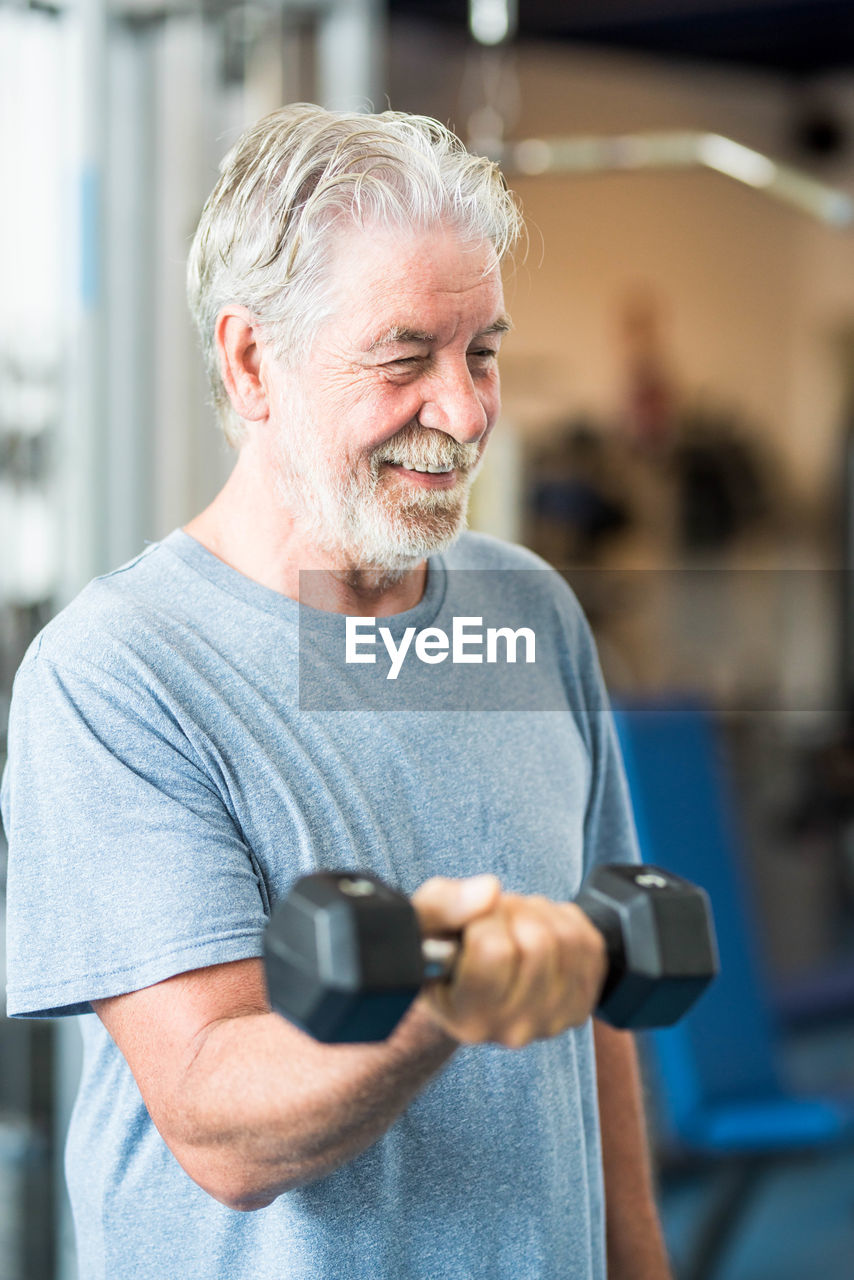 Man holding camera while standing at home