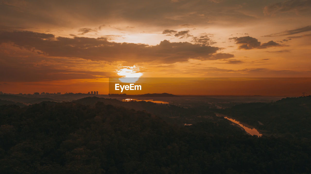 Amazing aerial view on the orange sky, sunset sun and clouds.