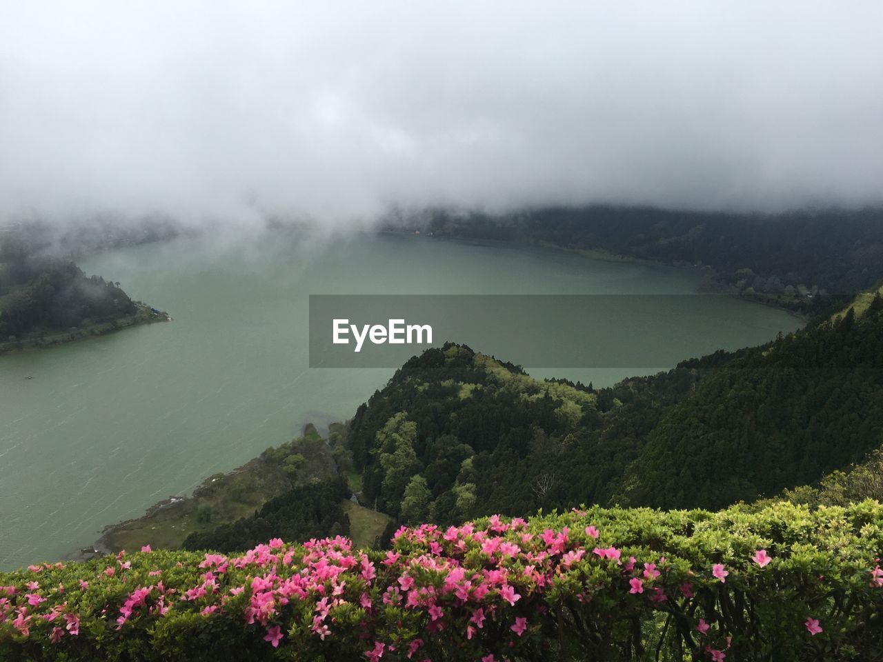 SCENIC VIEW OF LAKE BY MOUNTAINS DURING FOGGY WEATHER