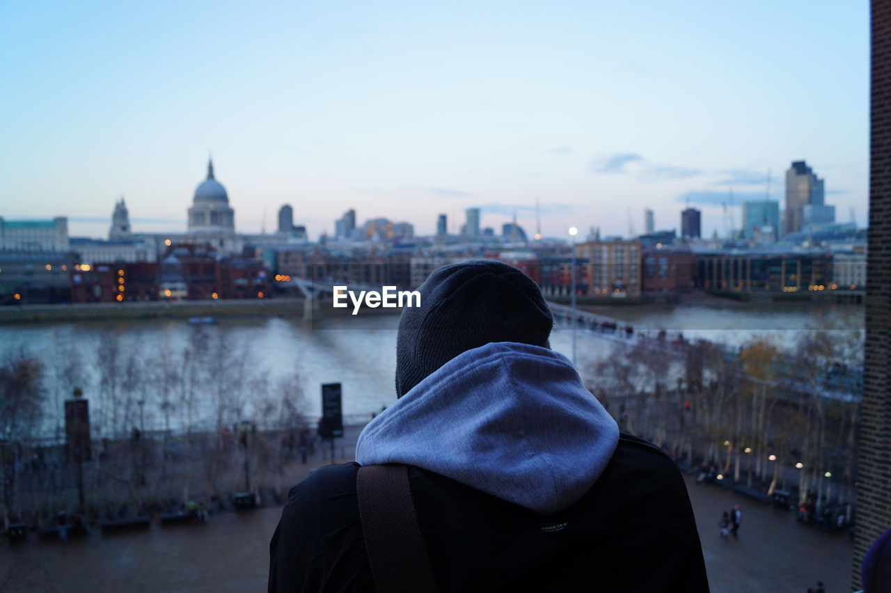 Rear view of man looking at cityscape