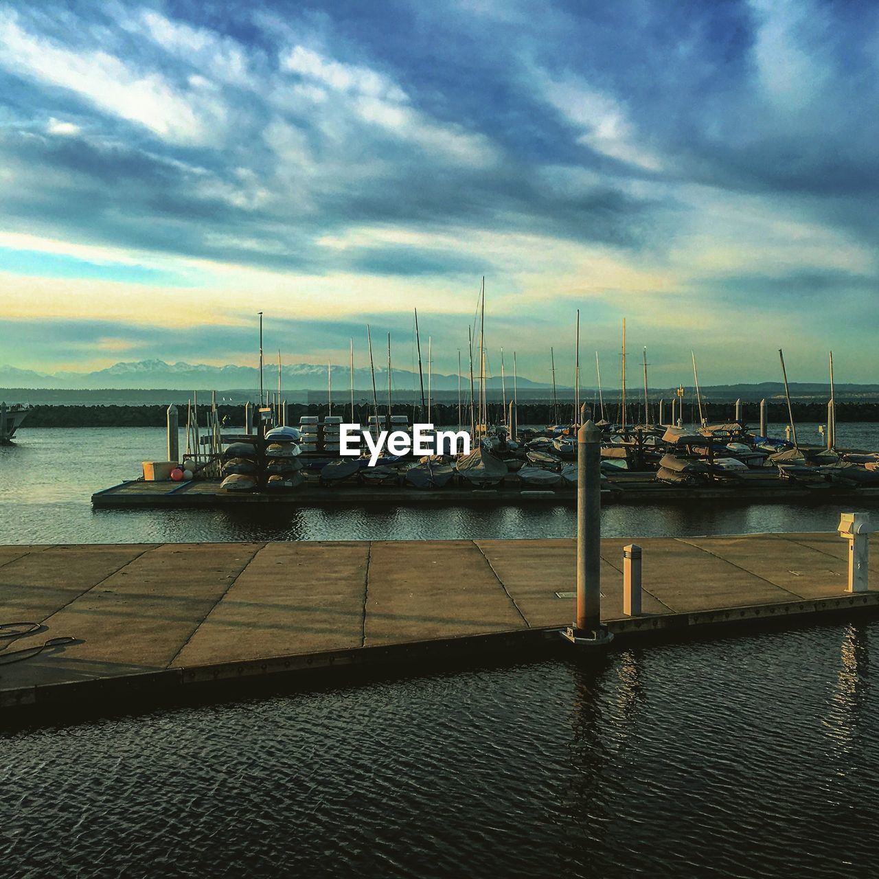 BOATS MOORED IN HARBOR AGAINST SKY