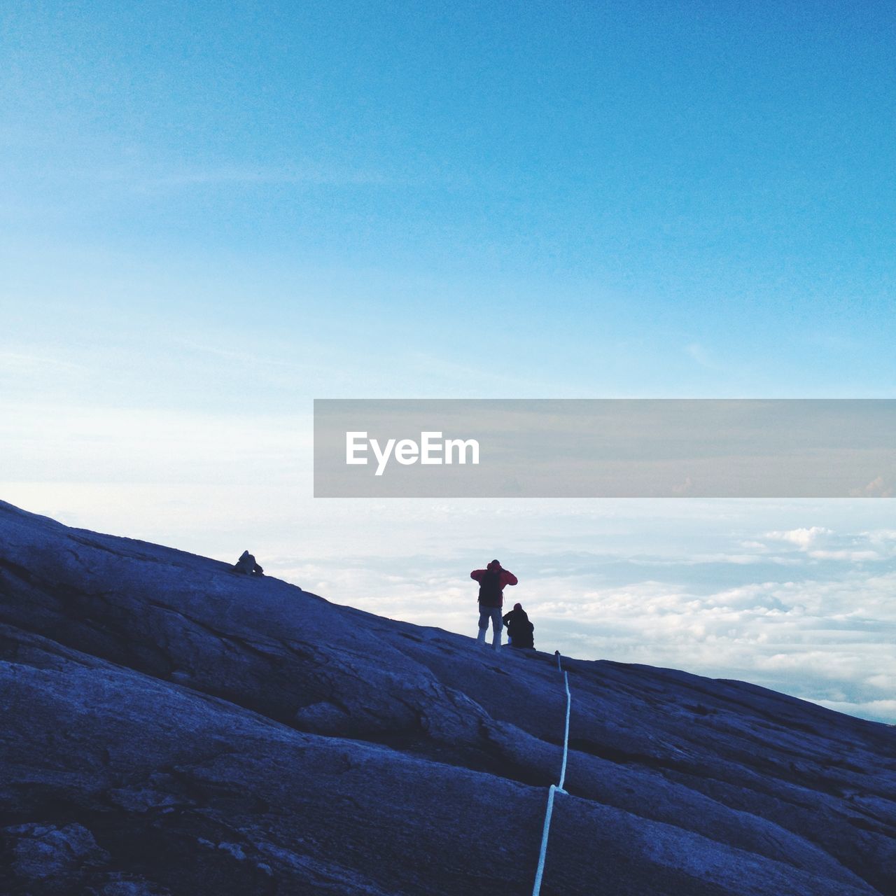 People mountain climbing against sky