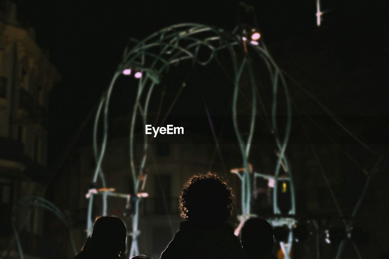 Rear view of children enjoying circus at night