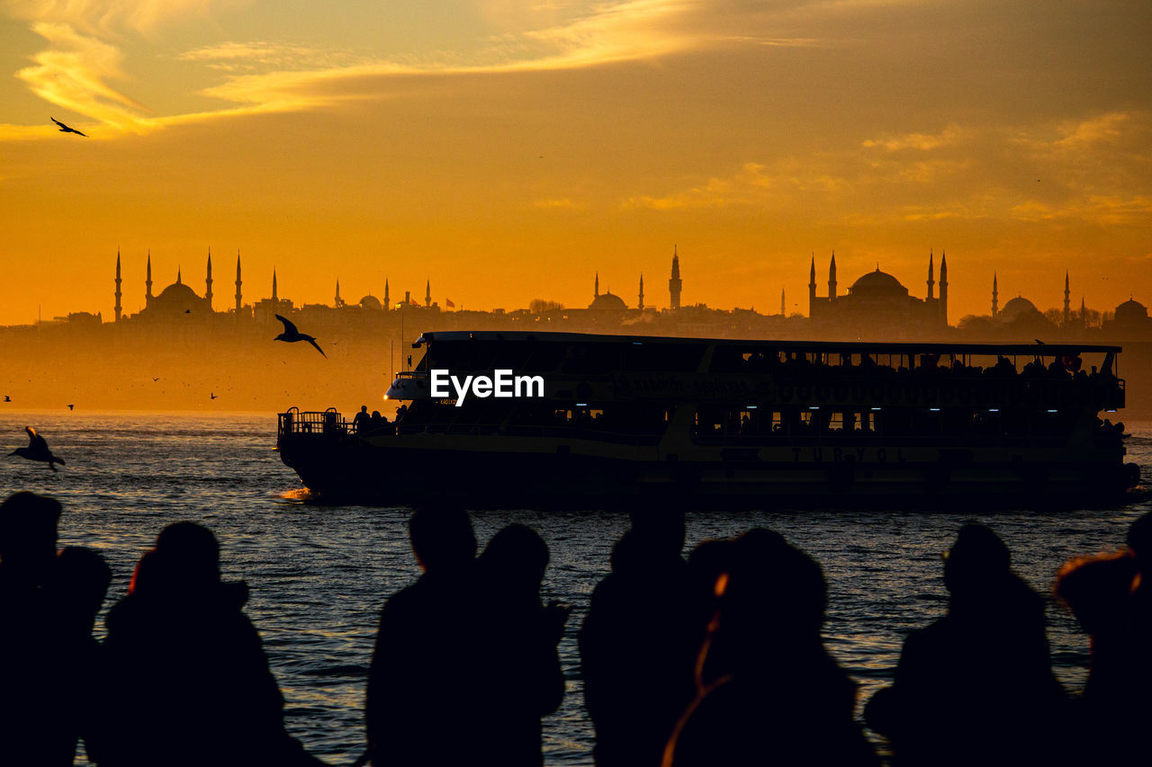 Istanbul silhouette of people on boat in sea during sunset