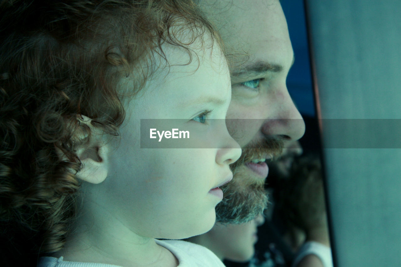 Close-up of daughter and father looking away