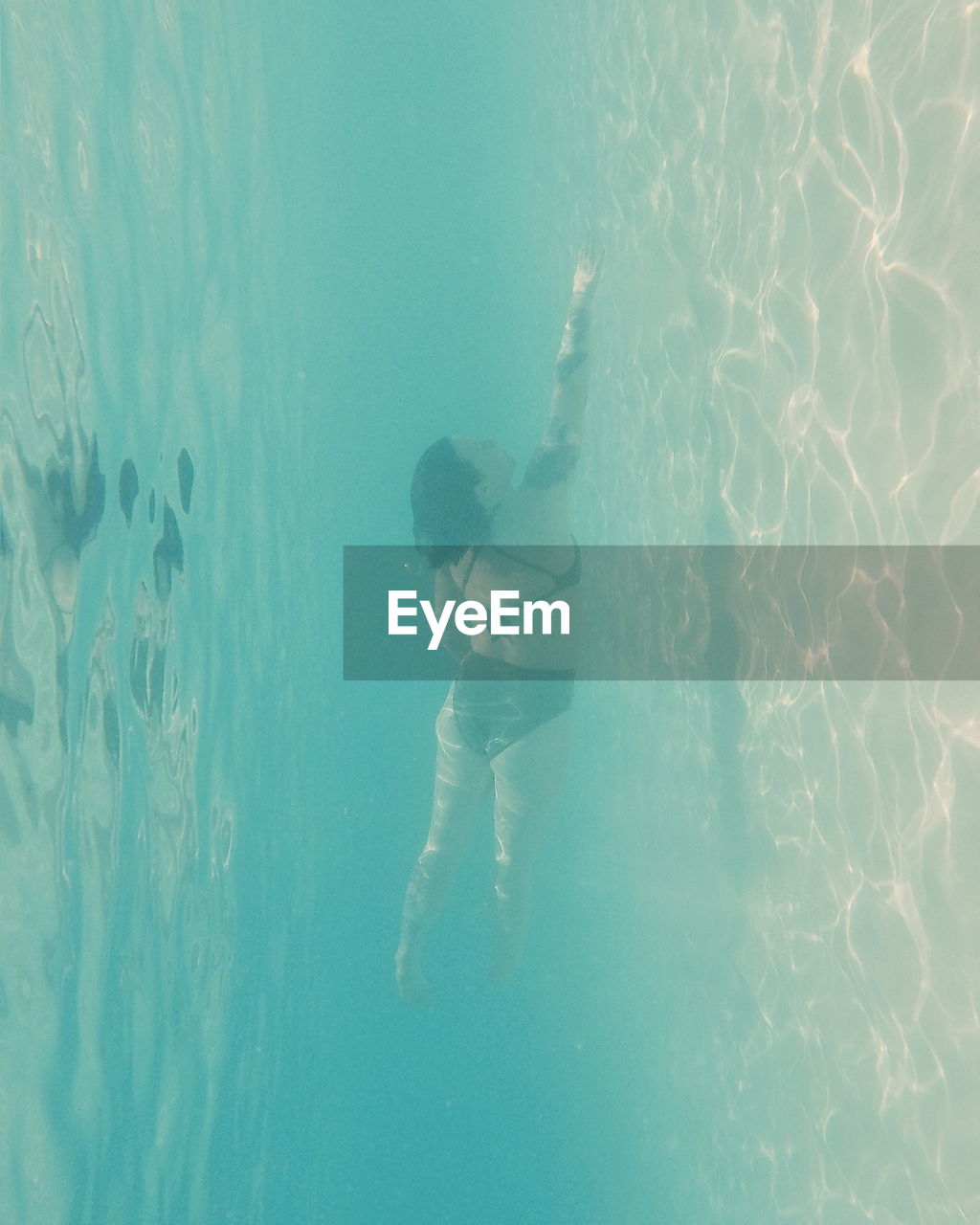 REAR VIEW OF WOMAN STANDING ON SWIMMING POOL