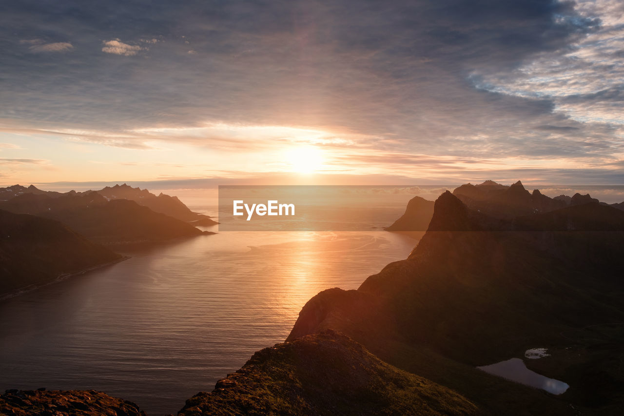 Scenic view of sea and mountains against sky during sunset