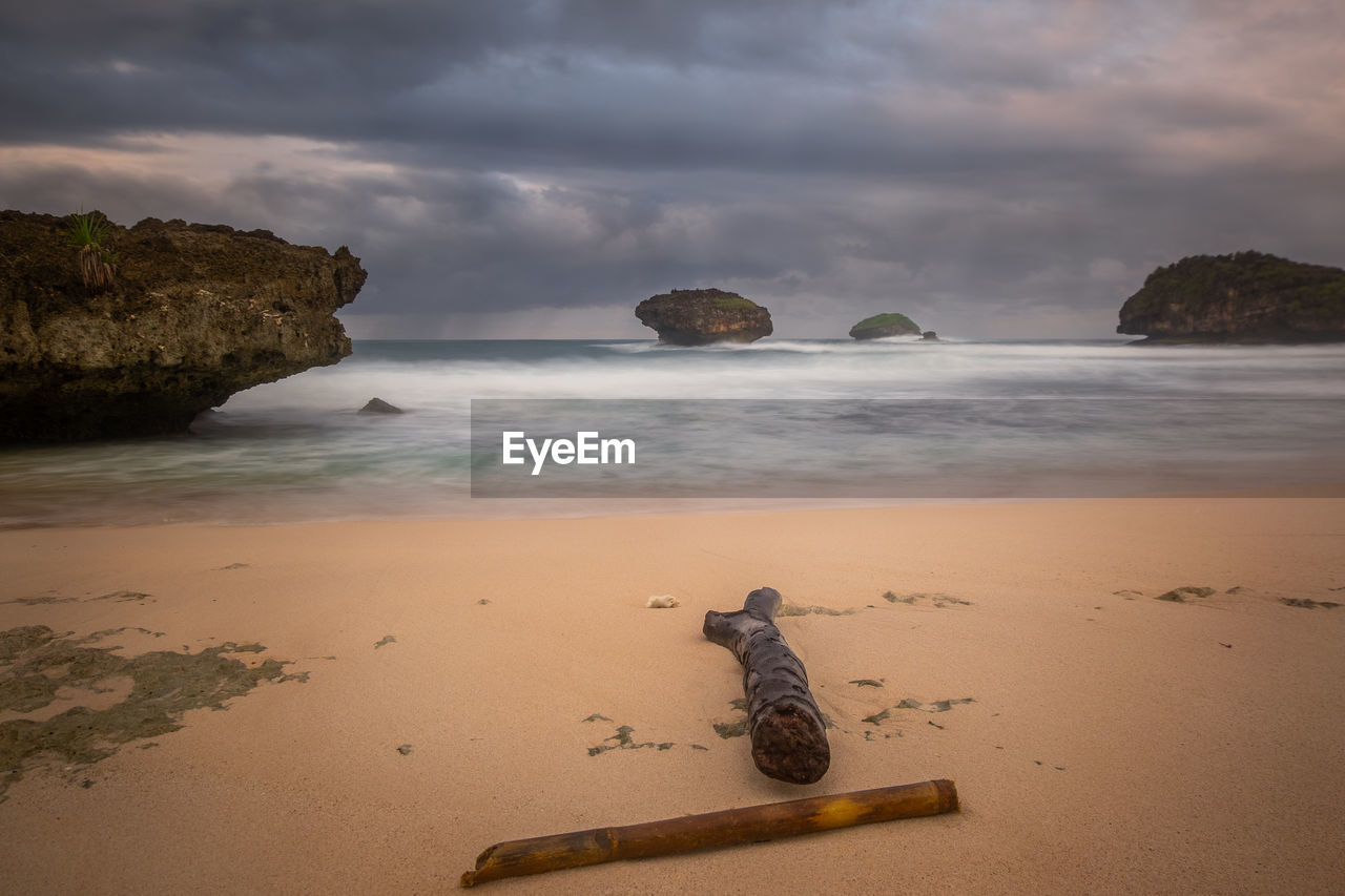 Scenic view of rocks on beach against sky