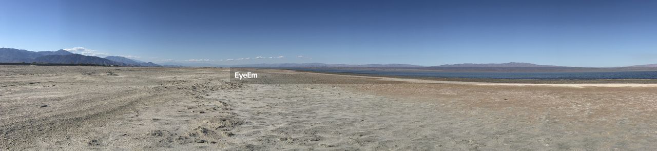 Scenic view of desert against clear blue sky