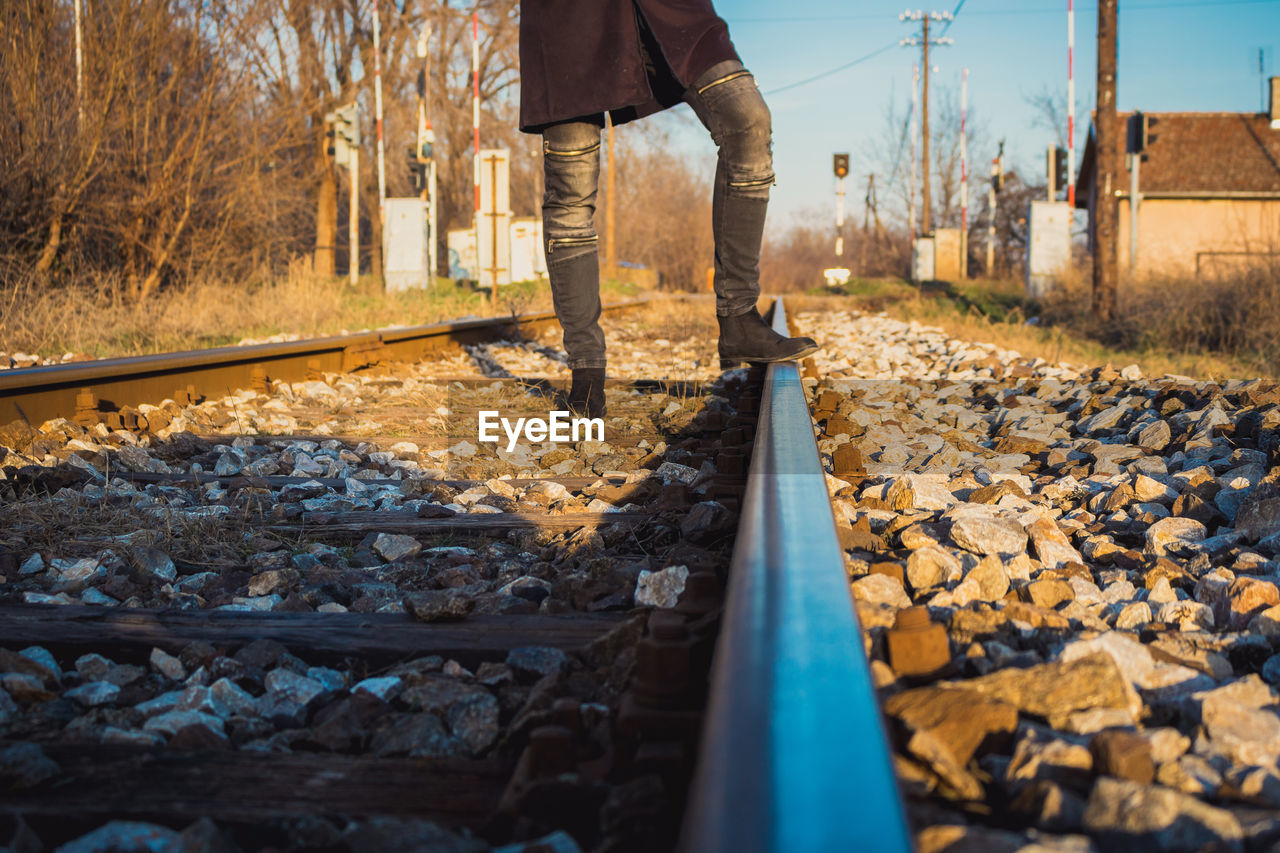 LOW SECTION OF MAN STANDING ON RAILROAD TRACKS