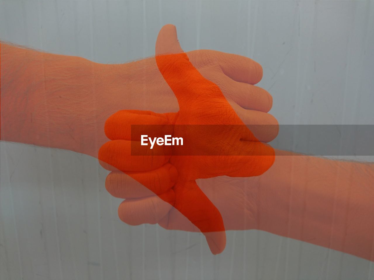 Digital composite image of hands gesturing against wall