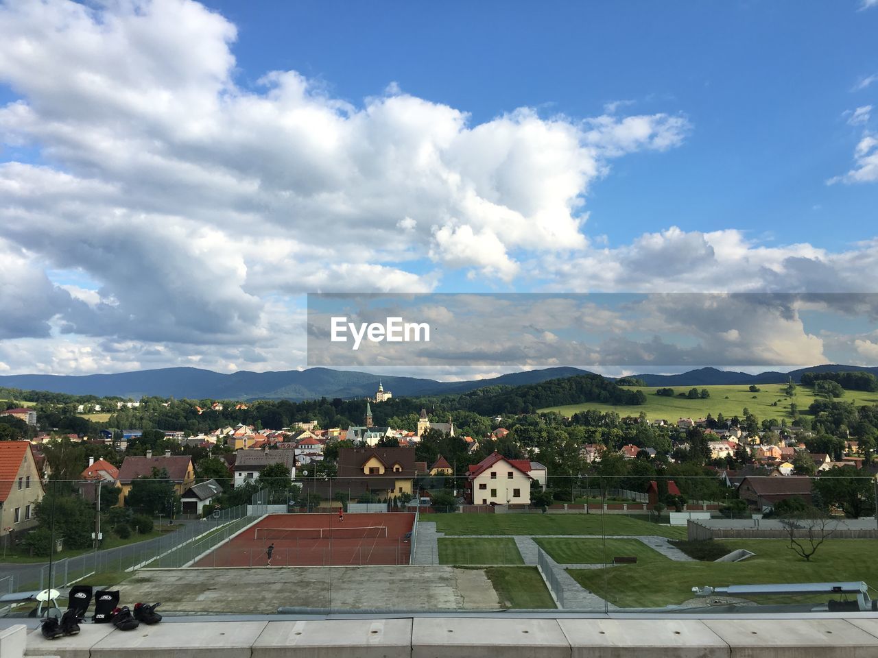 VIEW OF TOWN AGAINST CLOUDY SKY