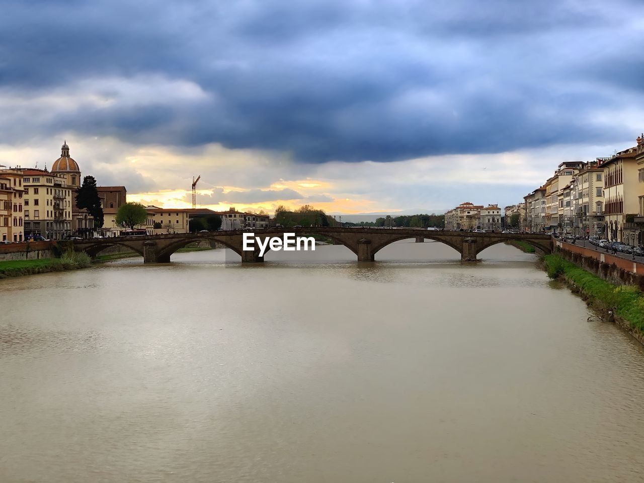 ARCH BRIDGE OVER RIVER AGAINST BUILDINGS