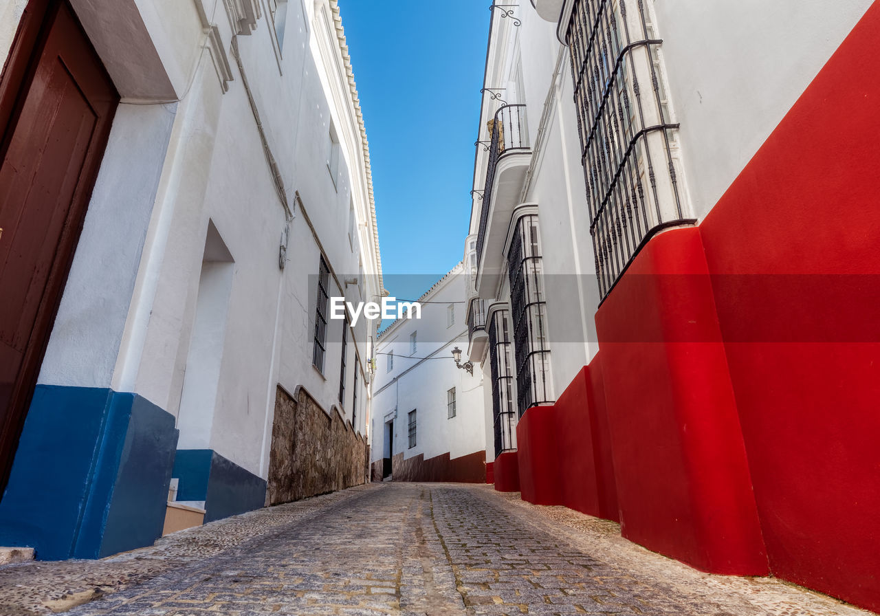 Footpath amidst buildings against sky