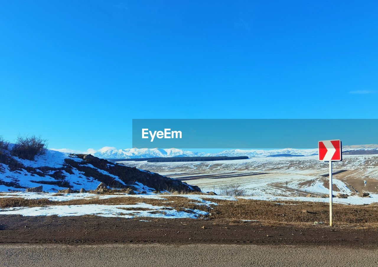 Scenic view of snowcapped mountains against blue sky