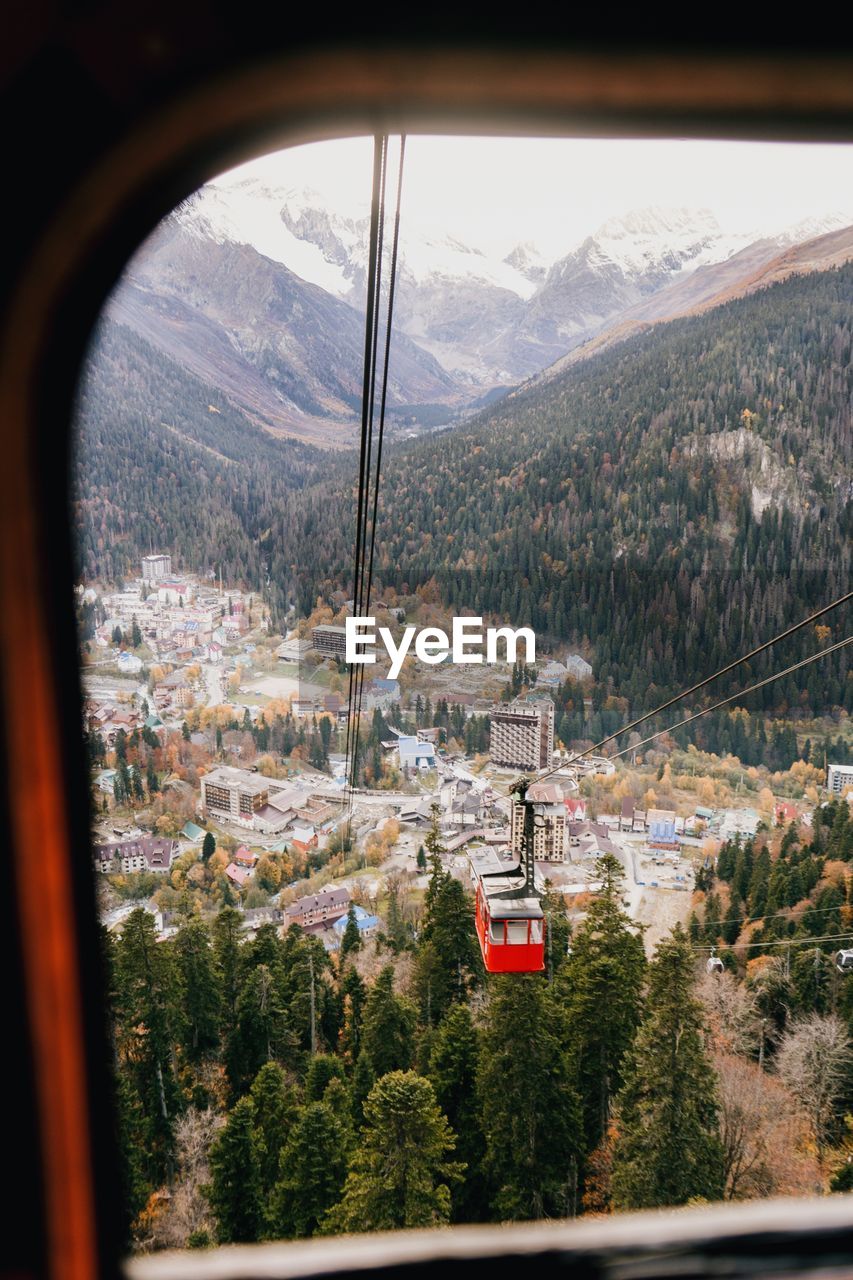 HIGH ANGLE VIEW OF OVERHEAD CABLE CAR AGAINST MOUNTAIN RANGE