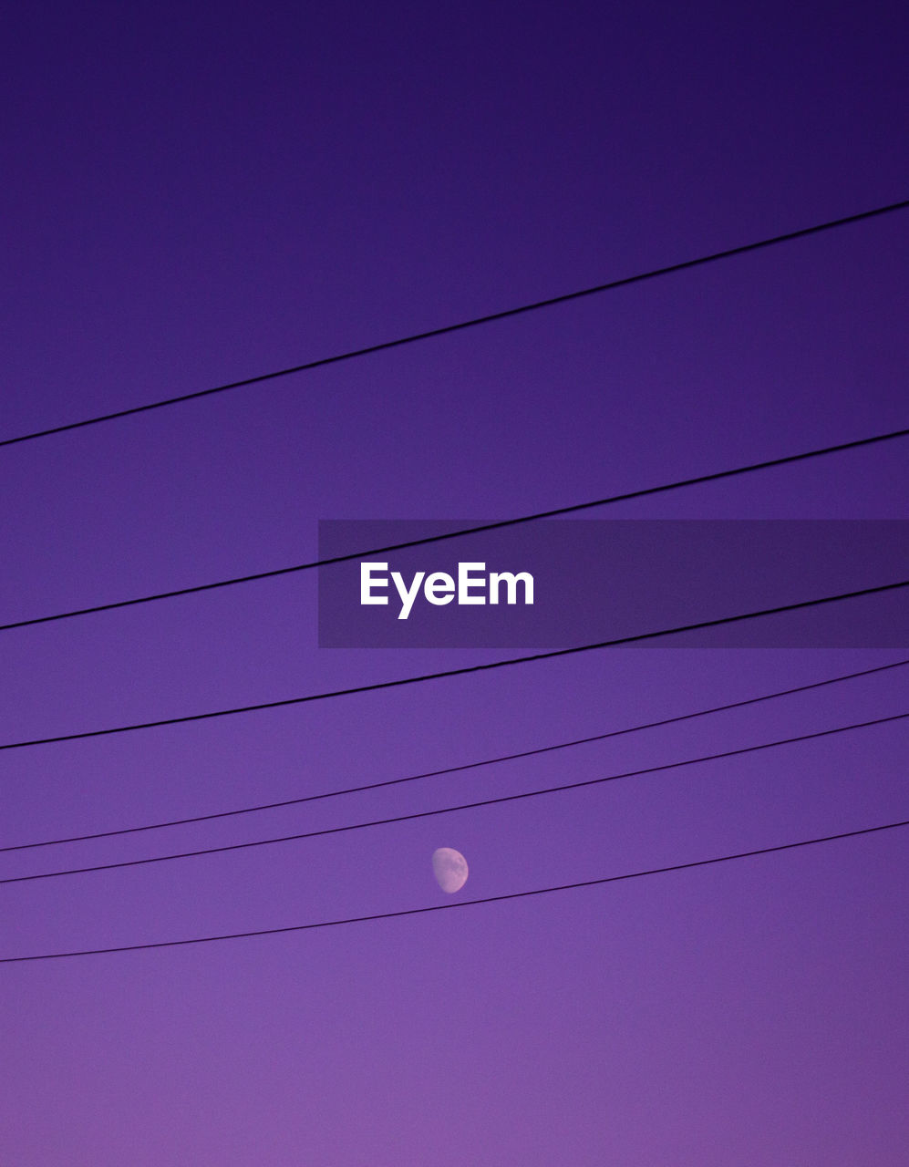 Low angle view of power lines against blue sky