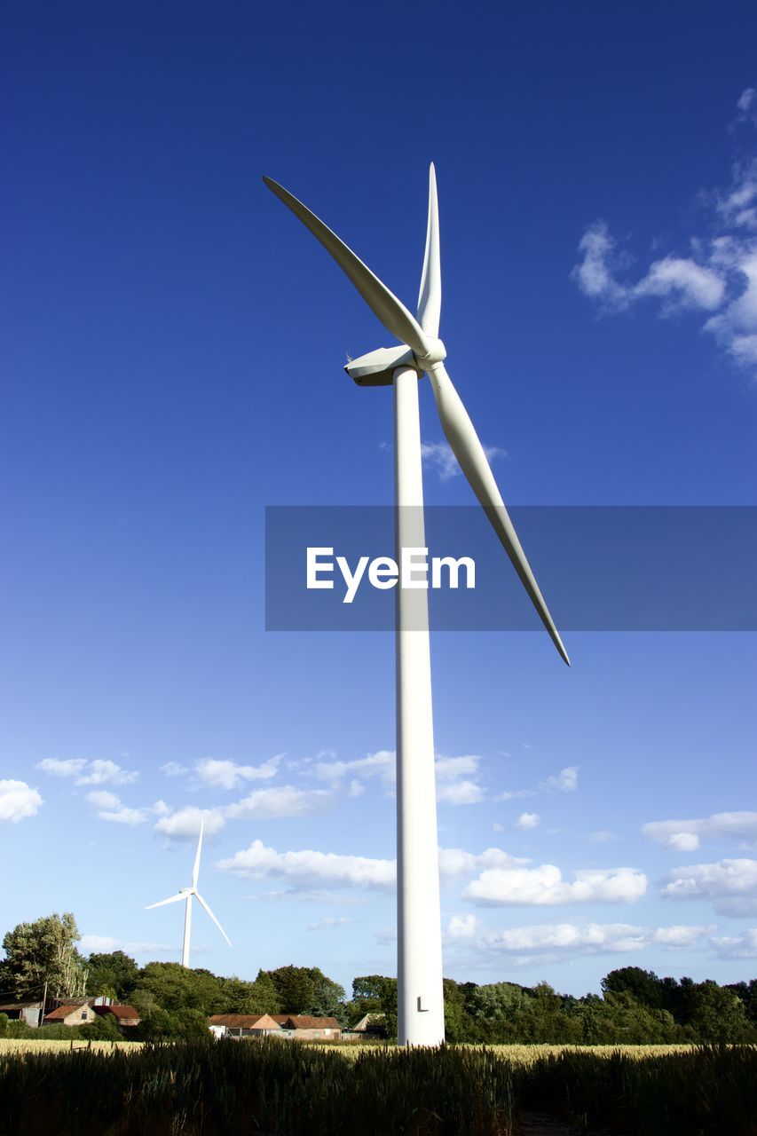 LOW ANGLE VIEW OF WIND TURBINES ON LAND