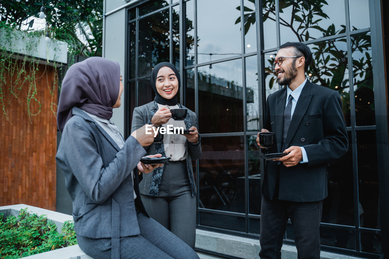 rear view of business people standing in front of building