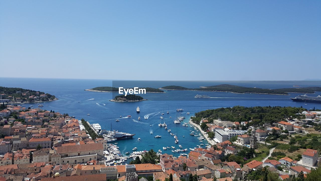 High angle view of town by sea against clear sky