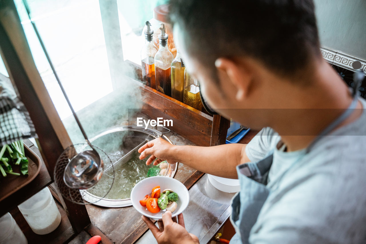 side view of man preparing food at home