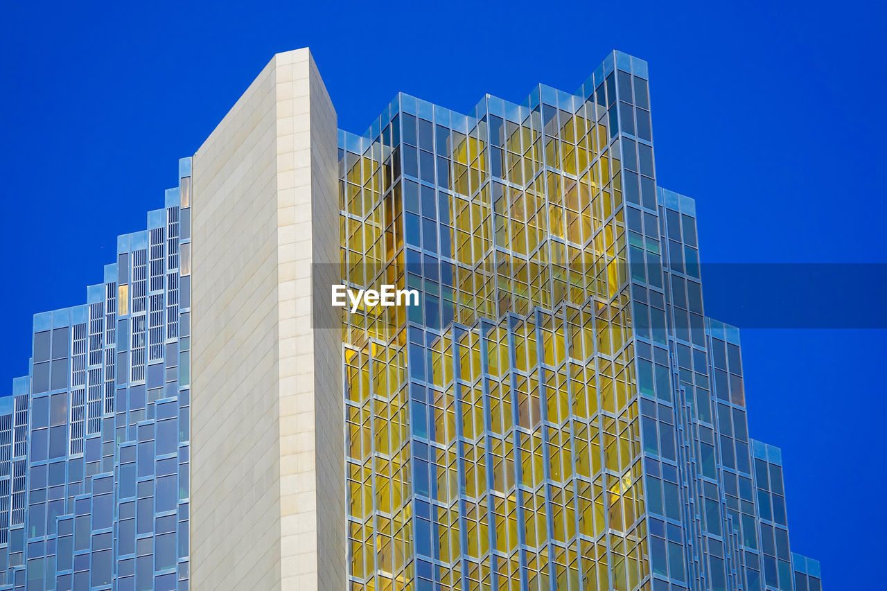LOW ANGLE VIEW OF MODERN BUILDING AGAINST CLEAR BLUE SKY